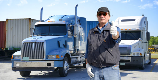 truck driver in front of his trucks